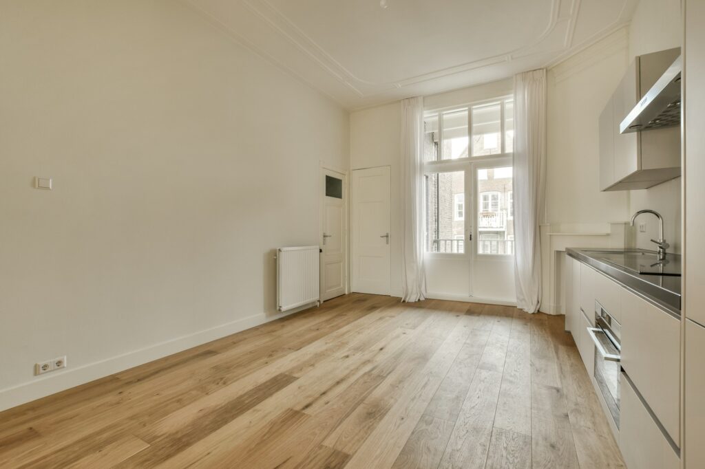 a living room with wood flooring and a window